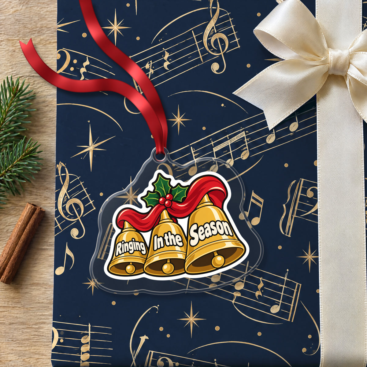 Ringing In the Season Handbells clear acrylic Christmas ornament lying on a gift wrapped in Rhythm and Beat music wrapping paper