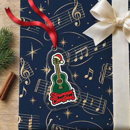 Strummin' Christmas Acoustic Guitar clear acrylic Christmas ornament lying on a gift wrapped in Rhythm and Beat music wrapping paper