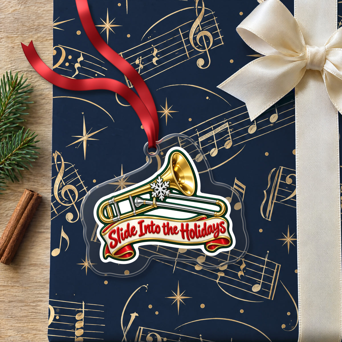 Slide Into the Holidays Trombone clear acrylic Christmas ornament lying on a gift wrapped in Rhythm and Beat music wrapping paper
