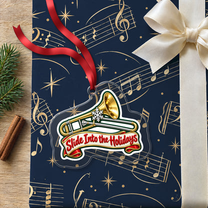 Slide Into the Holidays Trombone clear acrylic Christmas ornament lying on a gift wrapped in Rhythm and Beat music wrapping paper