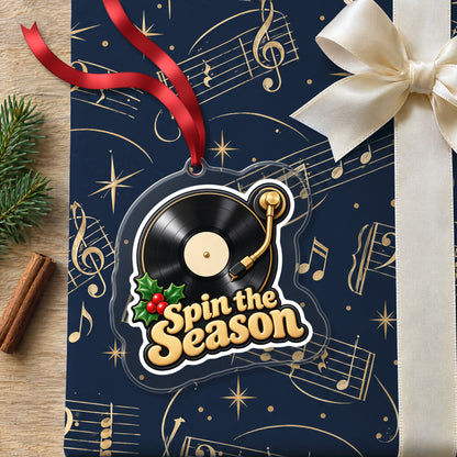 Spin the Season Vinyl Record clear acrylic Christmas ornament lying on a gift wrapped in Rhythm and Beat music wrapping paper