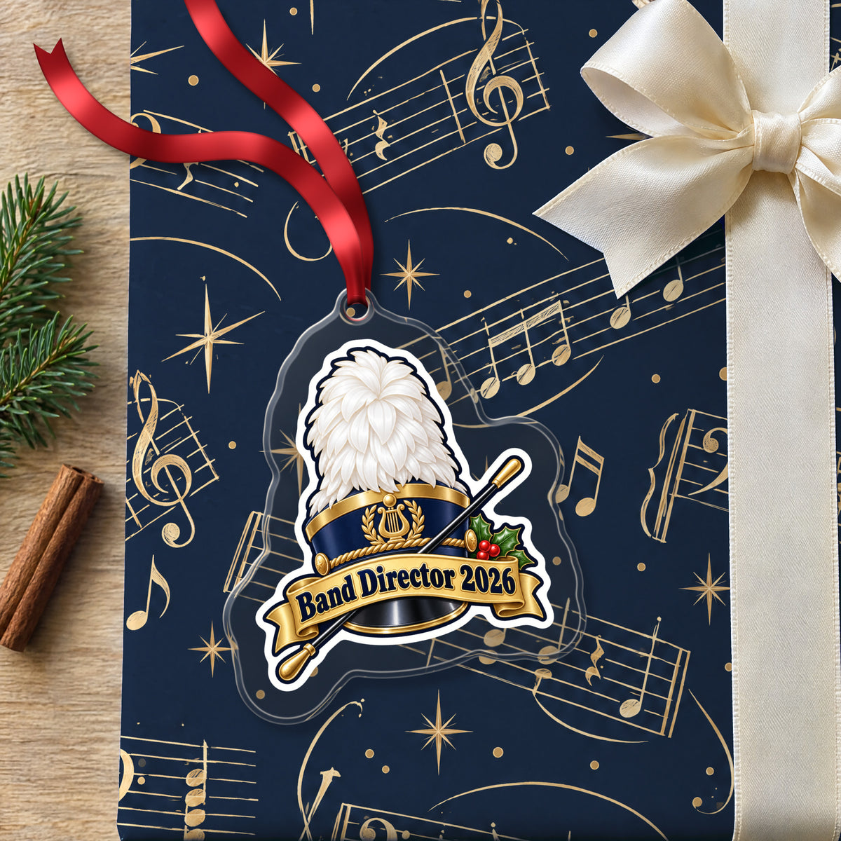 Band Director 2026 clear acrylic Christmas ornament lying on a gift wrapped in Rhythm and Beat music wrapping paper
