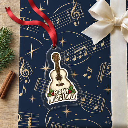 For My Music Lover Acoustic Guitar clear acrylic Christmas ornament lying on a gift wrapped in Rhythm and Beat music wrapping paper