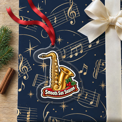 Smooth Sax Season Saxophone clear acrylic Christmas ornament lying on a gift wrapped in Rhythm and Beat music wrapping paper