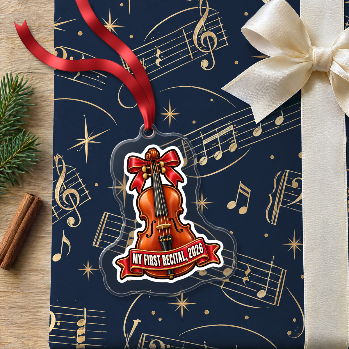 My First Violin Recital 2026 clear acrylic Christmas ornament lying on a gift wrapped in Rhythm and Beat music wrapping paper