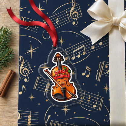 Little Violinist clear acrylic Christmas ornament lying on a gift wrapped in Rhythm and Beat music wrapping paper