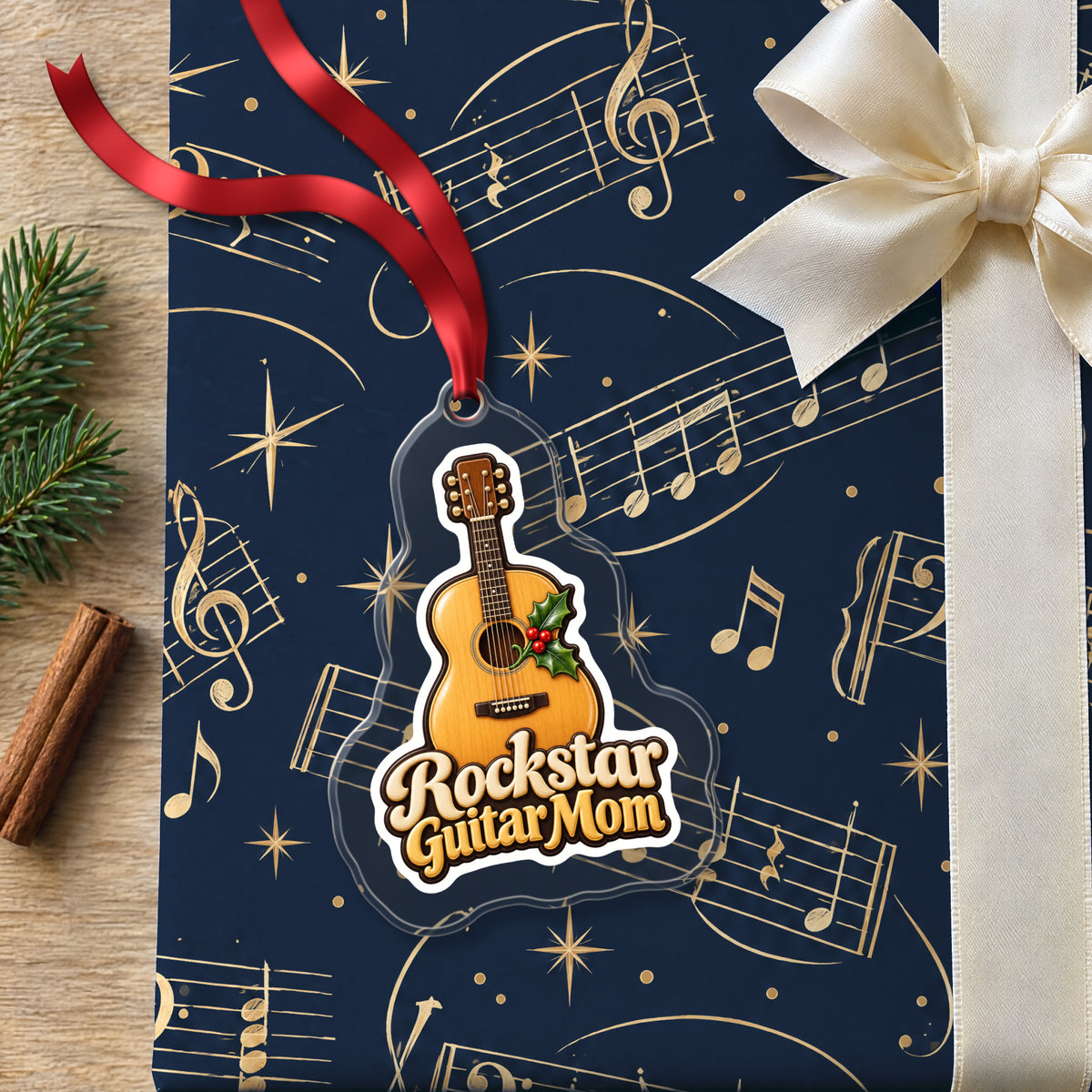Rockstar Guitar Mom clear acrylic Christmas ornament lying on a gift wrapped in Rhythm and Beat music wrapping paper