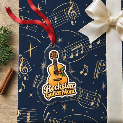 Rockstar Guitar Mom clear acrylic Christmas ornament lying on a gift wrapped in Rhythm and Beat music wrapping paper