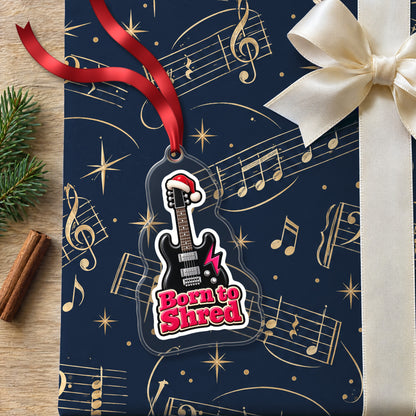 Born to Shred Electric Guitar clear acrylic Christmas ornament lying on a gift wrapped in Rhythm and Beat music wrapping paper