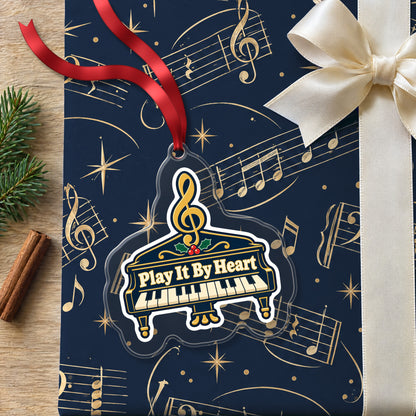Play It By Heart Grand Piano clear acrylic Christmas ornament lying on a gift wrapped in Rhythm and Beat music wrapping paper
