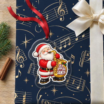 Sax Appeal Santa Saxophone clear acrylic Christmas ornament lying on a gift wrapped in Rhythm and Beat music wrapping paper