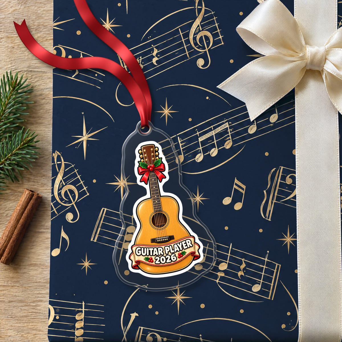 Guitar Player 2026 clear acrylic Christmas ornament lying on a gift wrapped in Rhythm and Beat music wrapping paper
