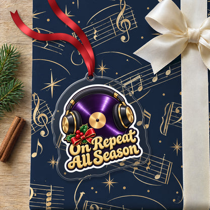 On Repeat Vinyl and Headphones clear acrylic Christmas ornament lying on a gift wrapped in Rhythm and Beat music wrapping paper