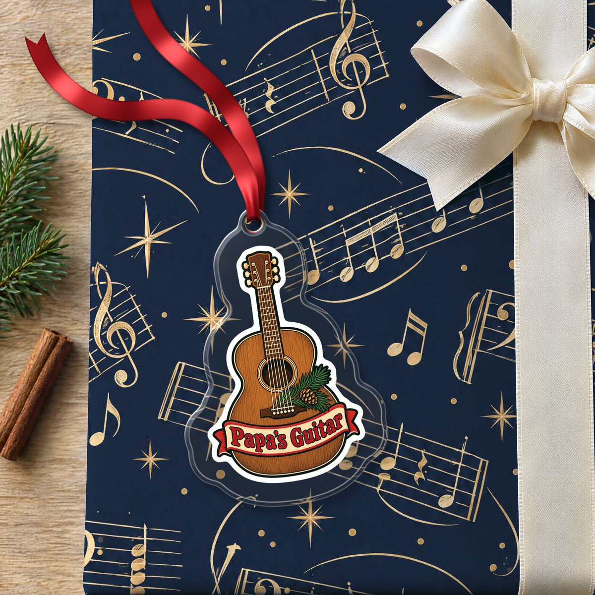 Papa's Guitar Christmas Ornament for Grandpa clear acrylic Christmas ornament lying on a gift wrapped in Rhythm and Beat music wrapping paper