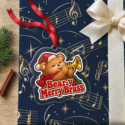 Bear-y Merry Brass Teddy Bear Trumpet clear acrylic Christmas ornament lying on a gift wrapped in Rhythm and Beat music wrapping paper