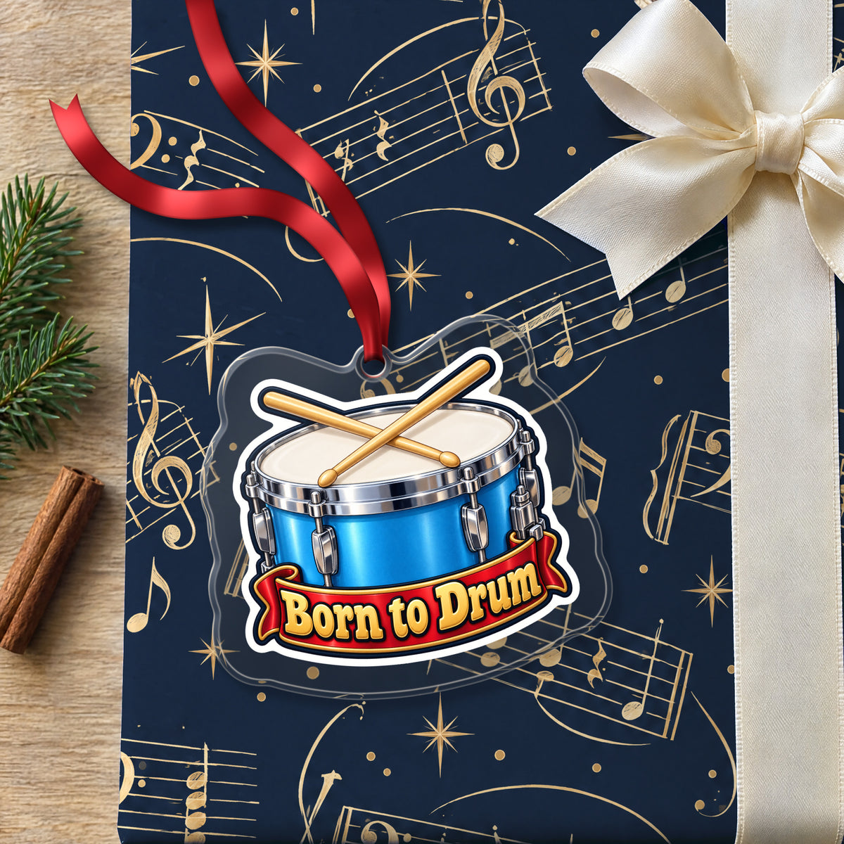 Born to Drum Snare Drum clear acrylic Christmas ornament lying on a gift wrapped in Rhythm and Beat music wrapping paper