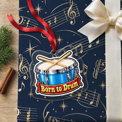 Born to Drum Snare Drum clear acrylic Christmas ornament lying on a gift wrapped in Rhythm and Beat music wrapping paper