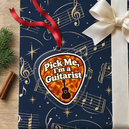 Pick Me, I'm a Guitarist Guitar Pick clear acrylic Christmas ornament lying on a gift wrapped in Rhythm and Beat music wrapping paper