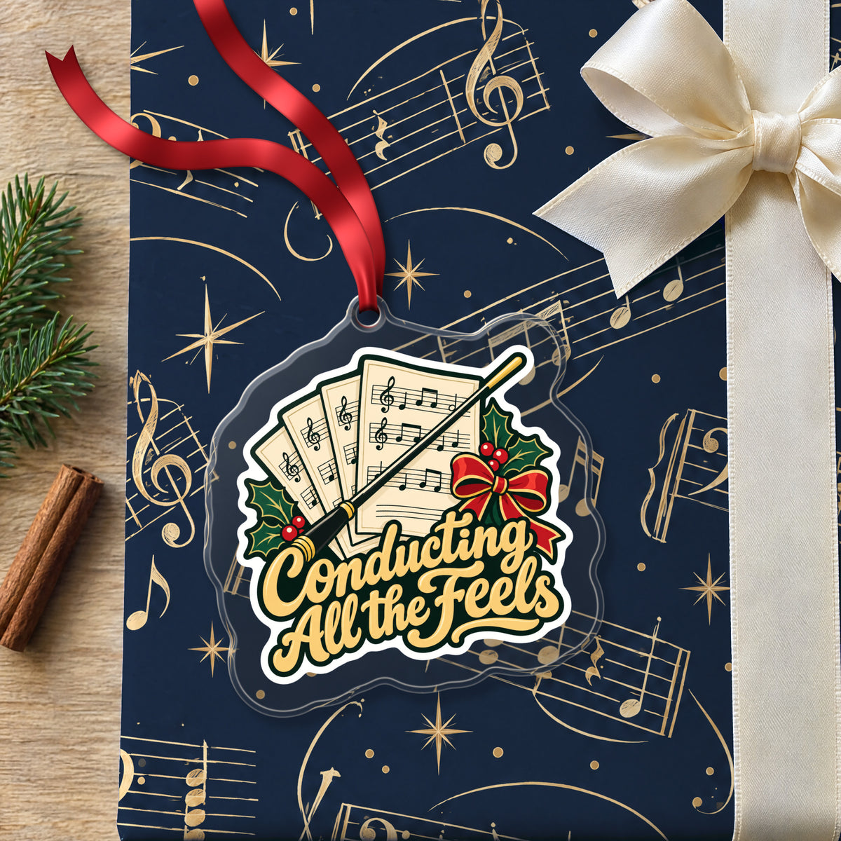 Conducting All the Feels Baton clear acrylic Christmas ornament lying on a gift wrapped in Rhythm and Beat music wrapping paper