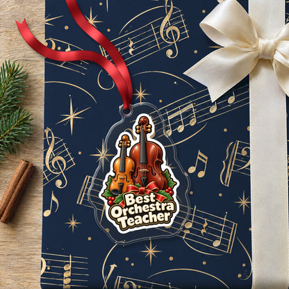 Best Orchestra Teacher clear acrylic Christmas ornament lying on a gift wrapped in Rhythm and Beat music wrapping paper