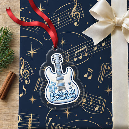 Rocking All Season Electric Guitar clear acrylic Christmas ornament lying on a gift wrapped in Rhythm and Beat music wrapping paper
