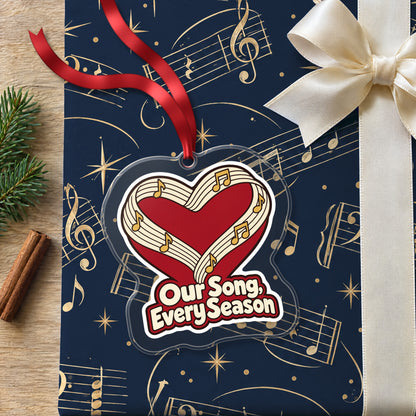 Our Song, Every Season Sheet Music Heart clear acrylic Christmas ornament lying on a gift wrapped in Rhythm and Beat music wrapping paper
