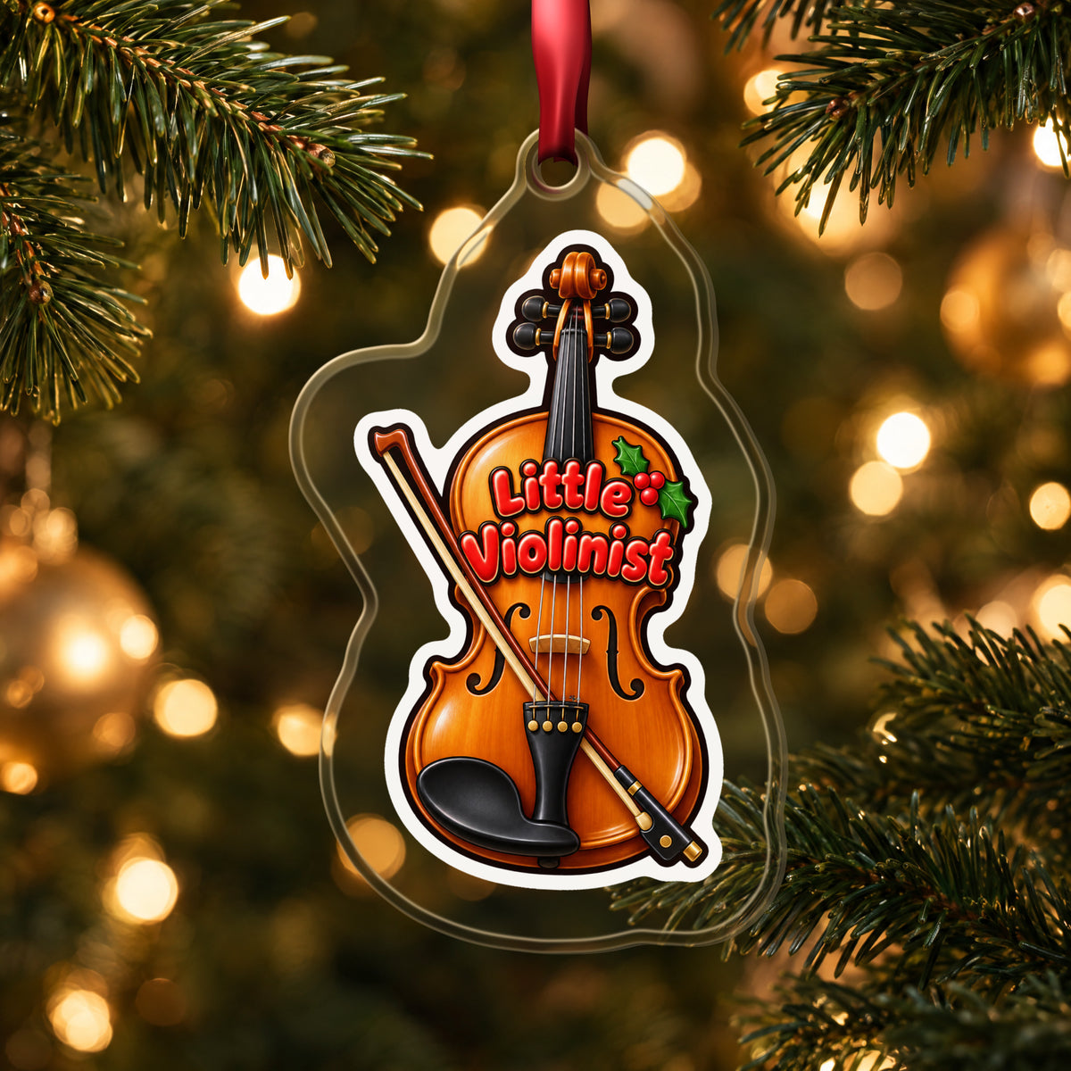Little Violinist clear acrylic Christmas ornament hanging on a lit Christmas tree with warm gold lights