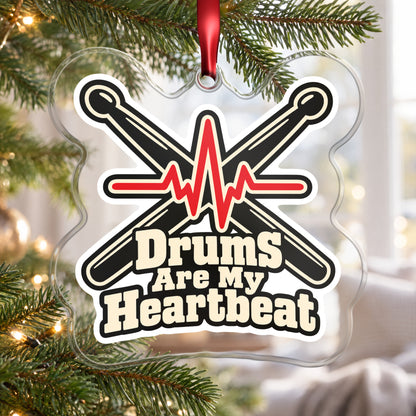 Drums Are My Heartbeat Drumsticks clear acrylic Christmas ornament hanging on a Christmas tree by a bright window