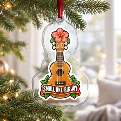 Small Uke, Big Joy Ukulele clear acrylic Christmas ornament hanging on a Christmas tree by a bright window