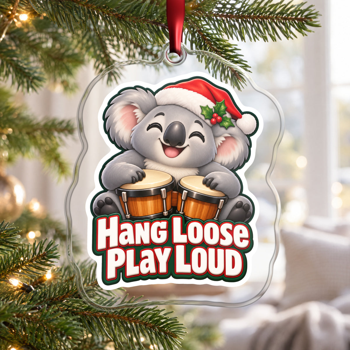 Hang Loose, Play Loud Koala Bongo clear acrylic Christmas ornament hanging on a Christmas tree by a bright window