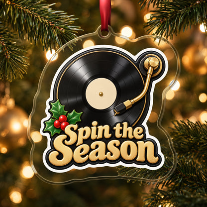 Spin the Season Vinyl Record clear acrylic Christmas ornament hanging on a lit Christmas tree with warm gold lights