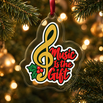 Music Is the Gift Treble Clef clear acrylic Christmas ornament hanging on a lit Christmas tree with warm gold lights
