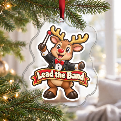 Lead the Band Reindeer Conductor clear acrylic Christmas ornament hanging on a Christmas tree by a bright window