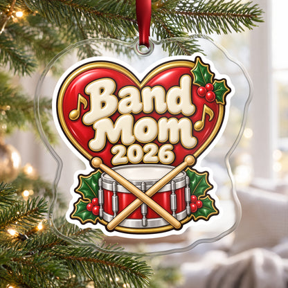 Band Mom 2026 clear acrylic Christmas ornament hanging on a Christmas tree by a bright window