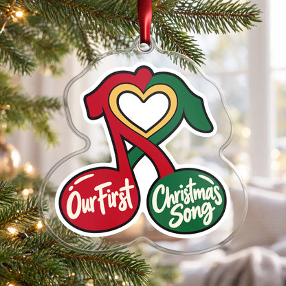 Our First Christmas Song Music Notes clear acrylic Christmas ornament hanging on a Christmas tree by a bright window