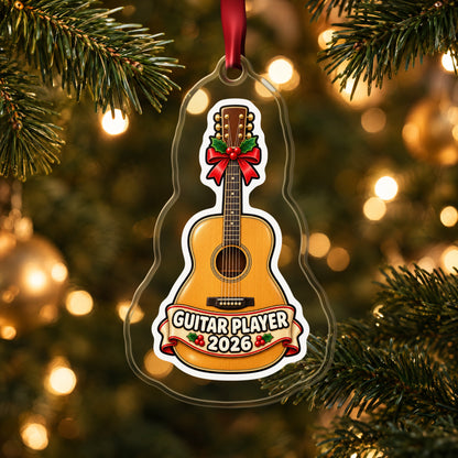 Guitar Player 2026 clear acrylic Christmas ornament hanging on a lit Christmas tree with warm gold lights
