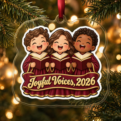 Joyful Voices 2026 Choir clear acrylic Christmas ornament hanging on a lit Christmas tree with warm gold lights