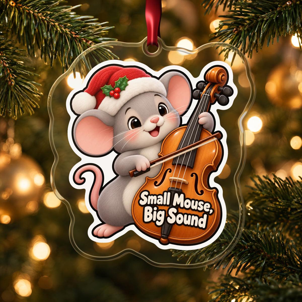 Small Mouse, Big Sound Cello clear acrylic Christmas ornament hanging on a lit Christmas tree with warm gold lights