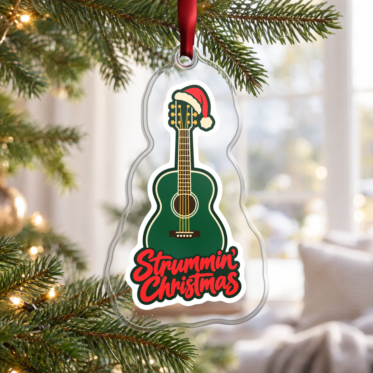 Strummin' Christmas Acoustic Guitar clear acrylic Christmas ornament hanging on a Christmas tree by a bright window