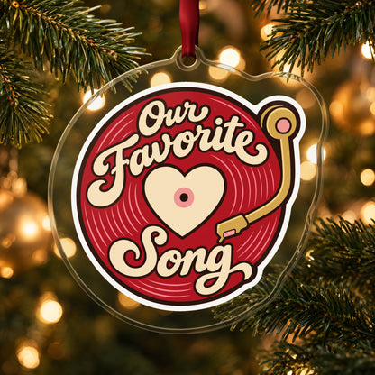 Our Favorite Song Vinyl Record clear acrylic Christmas ornament hanging on a lit Christmas tree with warm gold lights