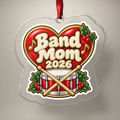 Band Mom 2026 clear acrylic Christmas ornament on a plain studio backdrop with its red ribbon