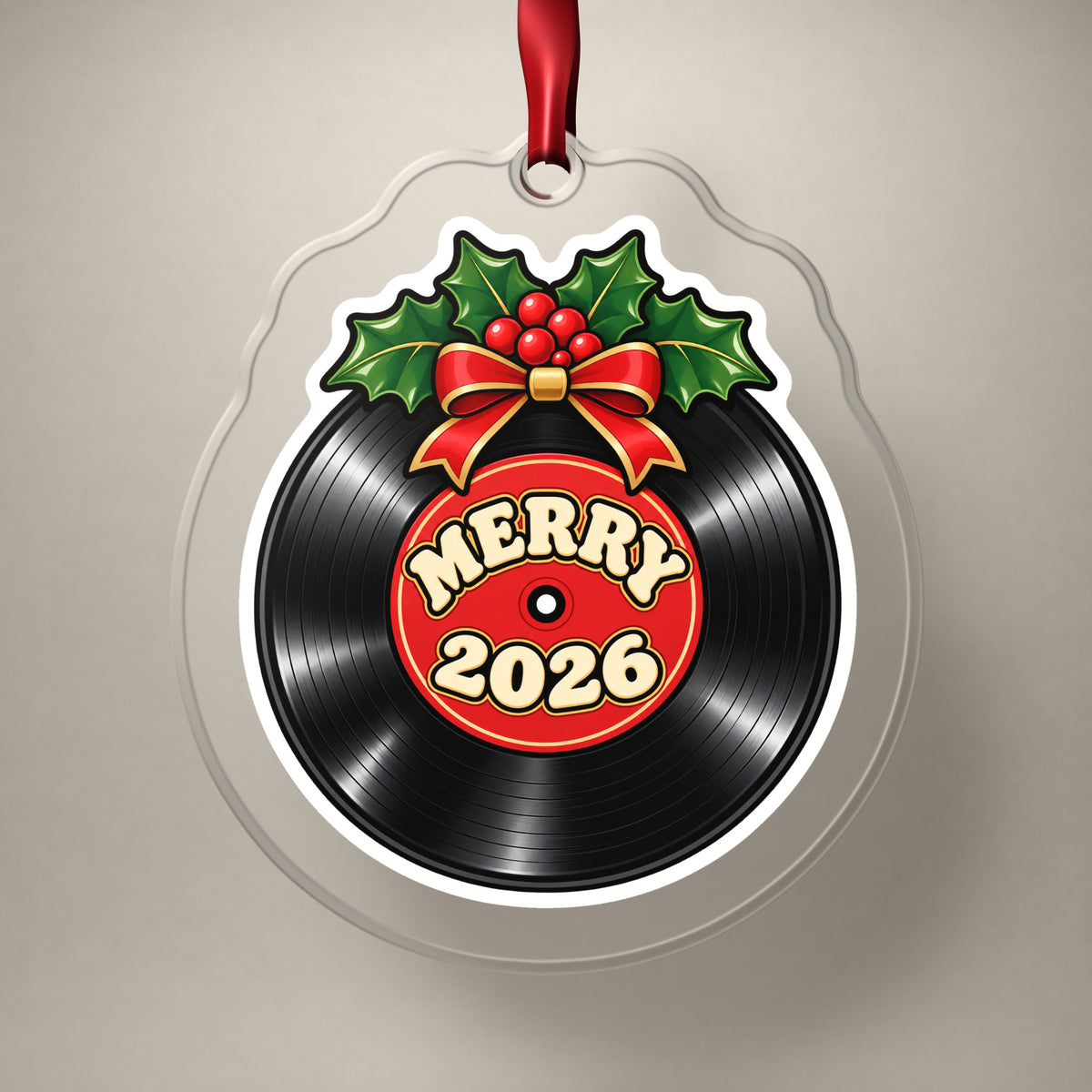 Merry 2026 Vinyl Record clear acrylic Christmas ornament on a plain studio backdrop with its red ribbon