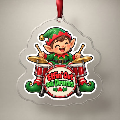 Elfin' Out on Drums Elf Drummer clear acrylic Christmas ornament on a plain studio backdrop with its red ribbon