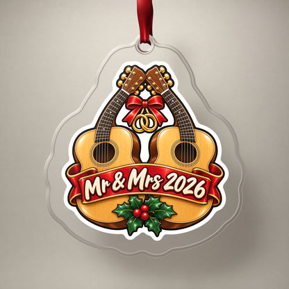 Mr & Mrs First Christmas 2026 Guitar clear acrylic Christmas ornament on a plain studio backdrop with its red ribbon