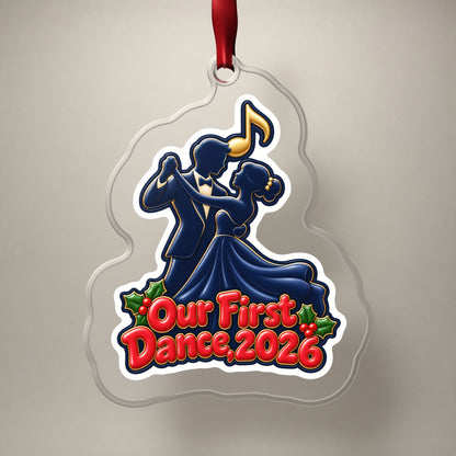Our First Dance 2026 Couple clear acrylic Christmas ornament on a plain studio backdrop with its red ribbon
