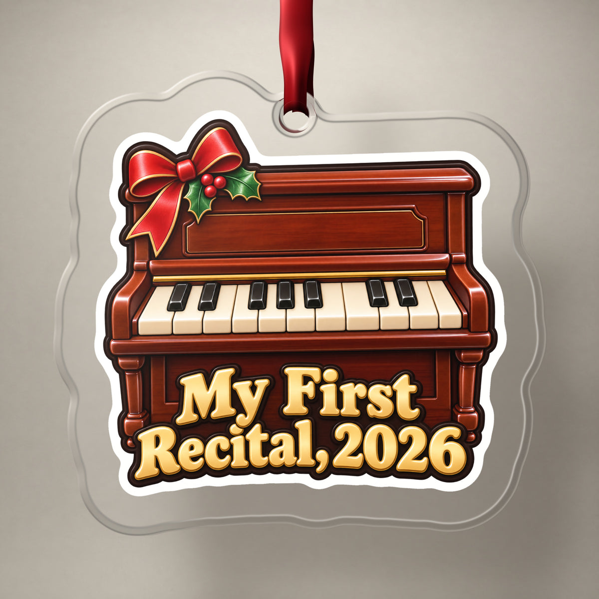 My First Piano Recital 2026 clear acrylic Christmas ornament on a plain studio backdrop with its red ribbon