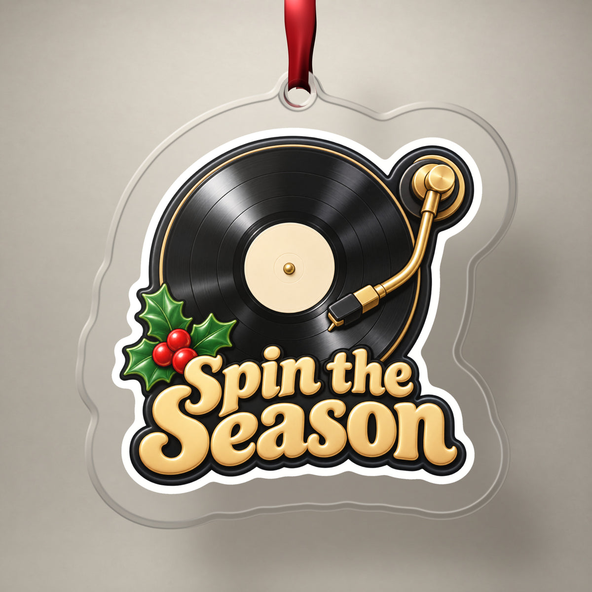 Spin the Season Vinyl Record clear acrylic Christmas ornament on a plain studio backdrop with its red ribbon