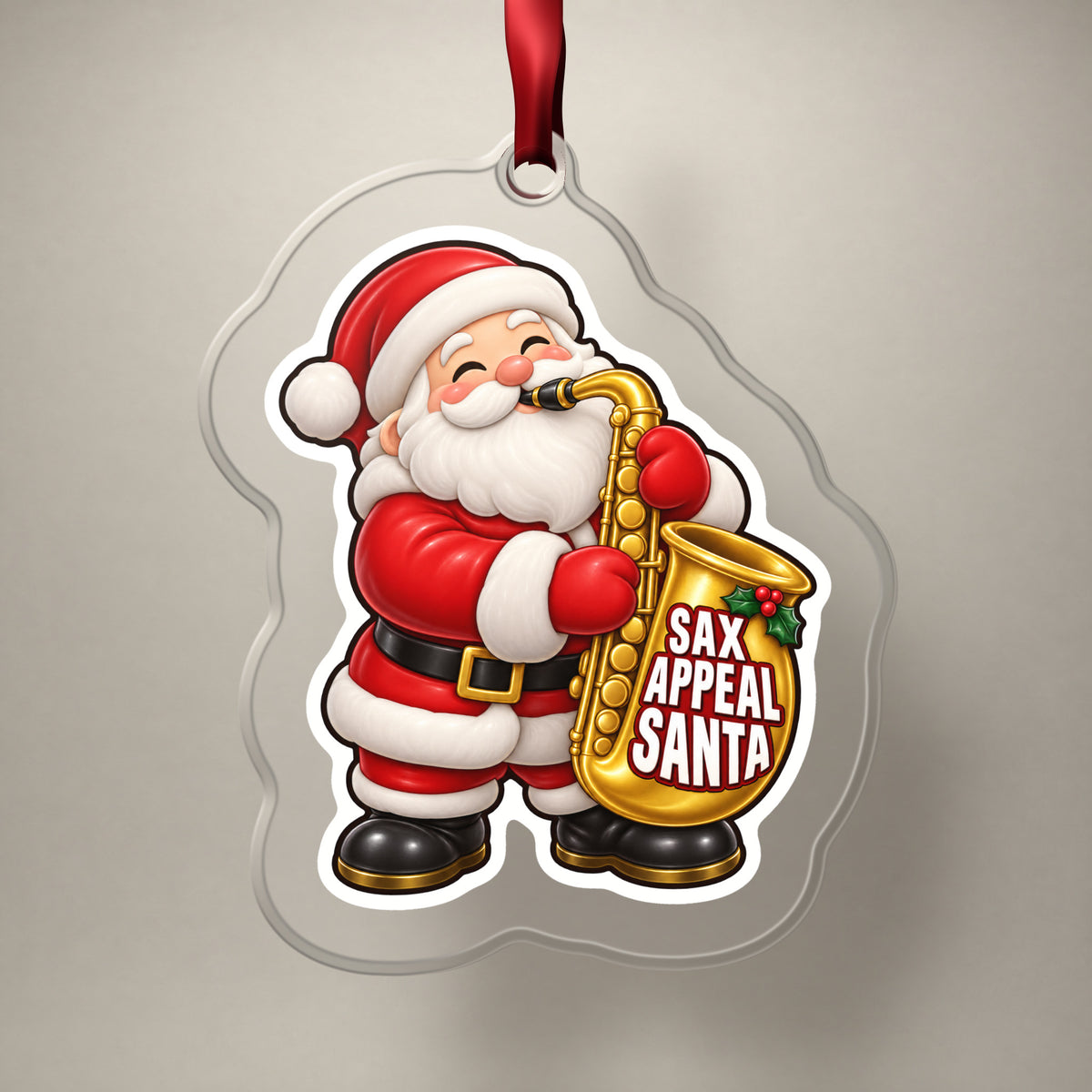 Sax Appeal Santa Saxophone clear acrylic Christmas ornament on a plain studio backdrop with its red ribbon
