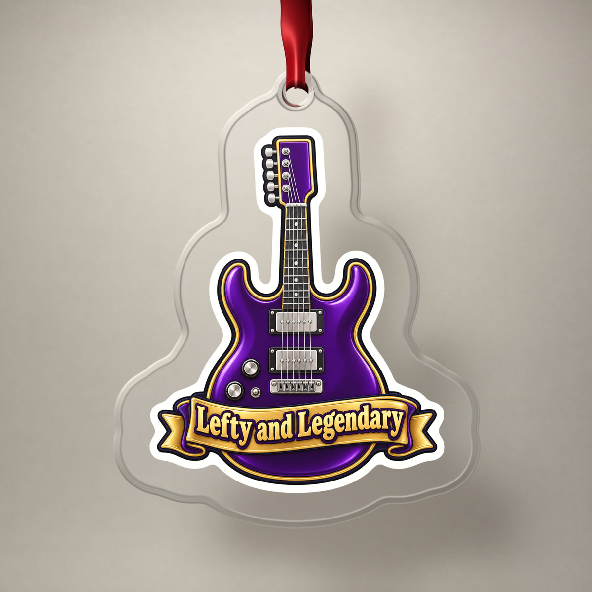 Lefty and Legendary Electric Guitar clear acrylic Christmas ornament on a plain studio backdrop with its red ribbon