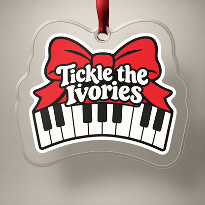 Tickle the Ivories Piano Keys clear acrylic Christmas ornament on a plain studio backdrop with its red ribbon